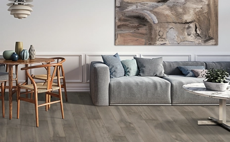wood look laminate flooring in living room with grey couch